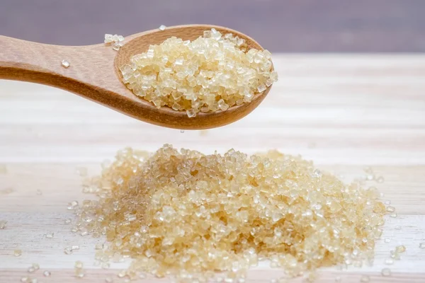 Brown sugar heap on wooden table — Stock Photo, Image