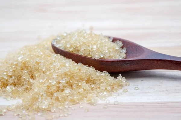 Brown sugar heap on wooden table — Stock Photo, Image