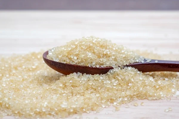 Hnědý cukr haldy na dřevěný stůl — Stock fotografie