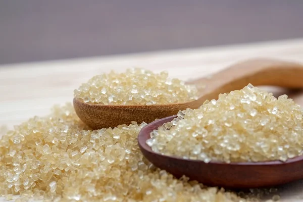 Hnědý cukr haldy na dřevěný stůl — Stock fotografie