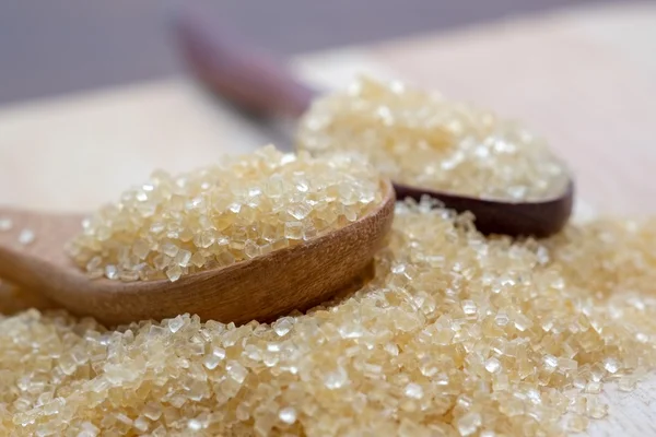 Brown sugar heap on wooden table — Stock Photo, Image