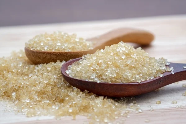 Brown sugar heap on wooden table — Stock Photo, Image