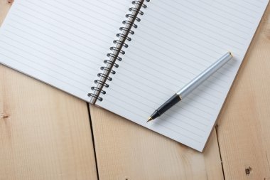 kalem ve kitap ahşap arka plan üzerinde