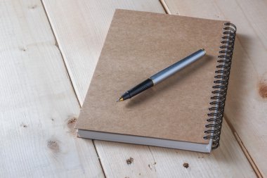 kalem ve kitap ahşap arka plan üzerinde