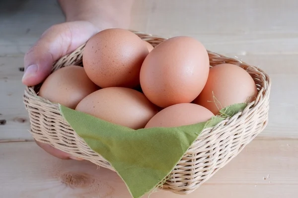 Hand holding egg on wooden background — Stock Photo, Image