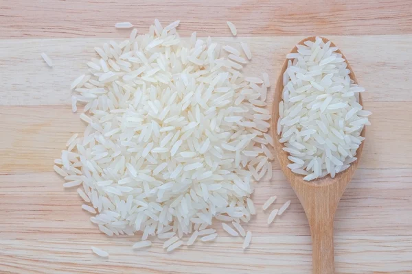 Jasmine rice and wooden spoon — Stock Photo, Image