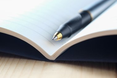 kalem ve kitap ahşap arka plan üzerinde