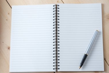kalem ve kitap ahşap arka plan üzerinde