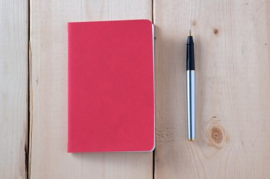 kalem ve kitap ahşap arka plan üzerinde