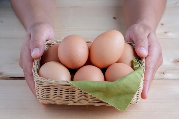 Hand holding egg on wooden background — Stock Photo, Image