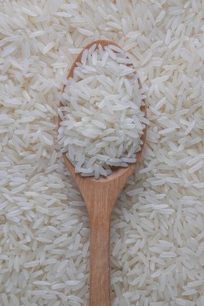 Arroz jasmim e colher de madeira — Fotografia de Stock