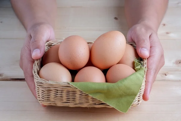Hand holding egg on wooden background Stock Picture