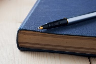 kalem ve kitap ahşap arka plan üzerinde