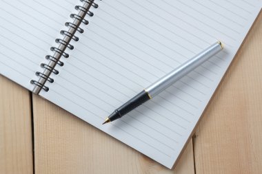 kalem ve kitap ahşap arka plan üzerinde