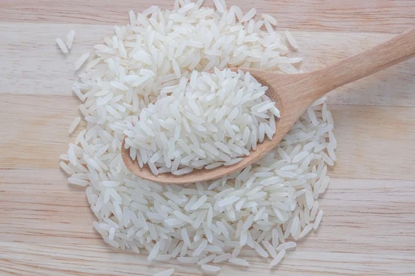 Jasmine rice and wooden spoon — Stock Photo, Image