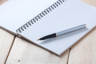 kalem ve kitap ahşap arka plan üzerinde