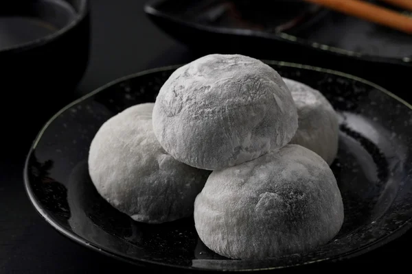 Japonês doce preto gergelim daifuku no fundo de madeira preta — Fotografia de Stock