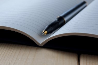 kalem ve kitap ahşap arka plan üzerinde