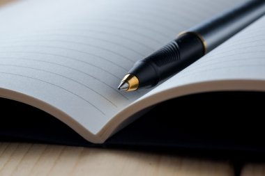 kalem ve kitap ahşap arka plan üzerinde