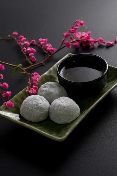 Japanese sweet black sesame daifuku on black wooden background