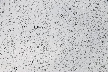 Pencere cam dokusu üzerine yağmur damlaları