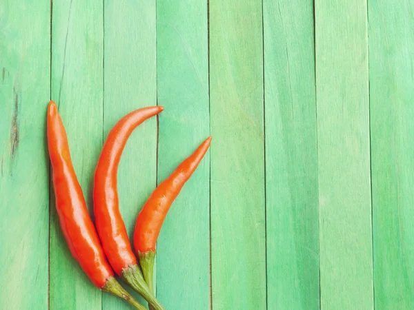 Rode hot chili peppers op groene houten oude retro vintage stijl — Stockfoto
