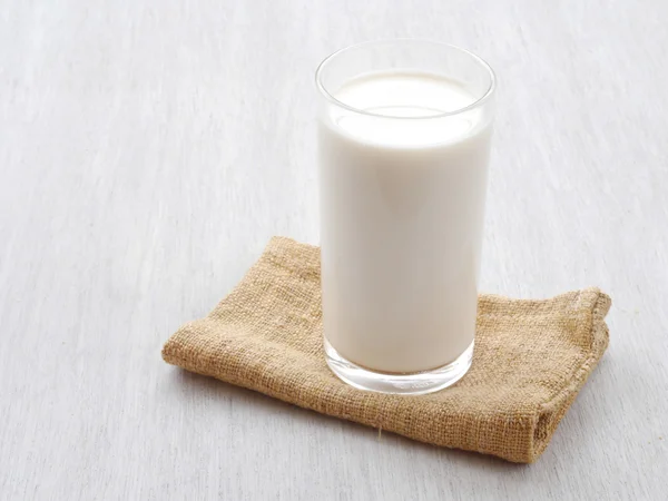Sklenici mléka na bílé dřevěné podlahy — Stock fotografie