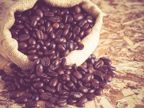 Кофейные зерна в мешке с эффектом фильтра ретро винтажный стиль — стоковое фото