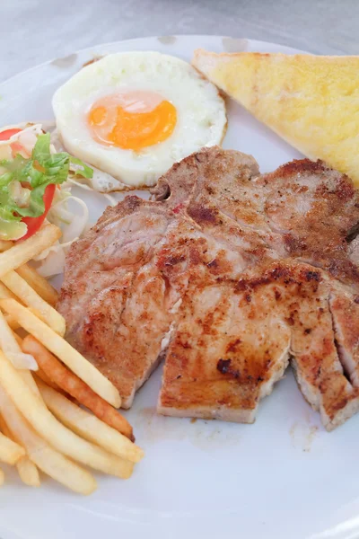 Filetes a la parrilla, papas fritas, huevo frito y verduras —  Fotos de Stock