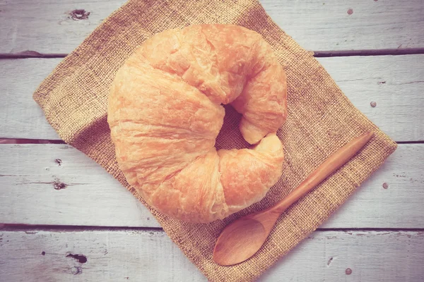 Verse Croissants op houten met retro filtereffect — Stockfoto