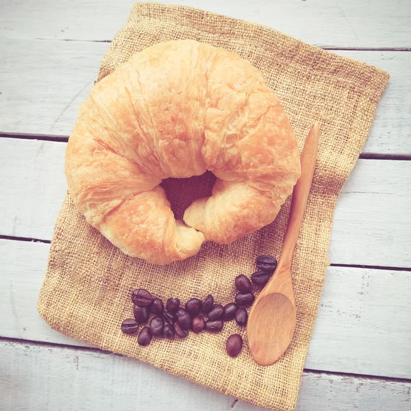 Verse Croissants op houten met retro filtereffect — Stockfoto