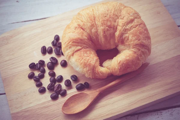 Verse Croissants op houten met retro filtereffect — Stockfoto