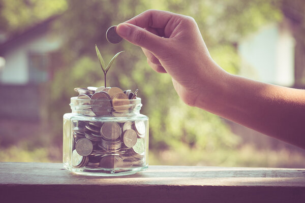 hand putting money coins  with filter effect retro vintage style