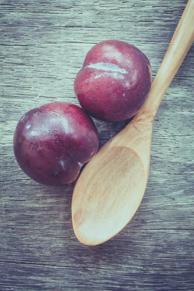 Ciruelas sobre fondo de madera con efecto filtro estilo vintage retro —  Fotos de Stock