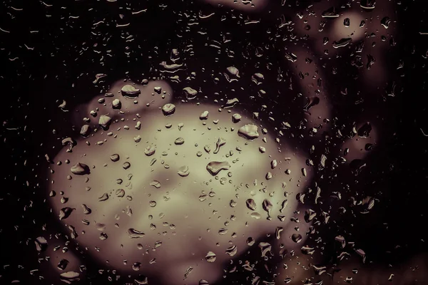 Gotas de lluvia sobre vidrio con efecto filtro estilo vintage retro — Foto de Stock