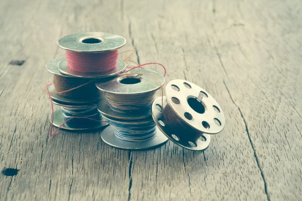 Thread rolls on wood background with filter effect retro vintage — Stock Photo, Image