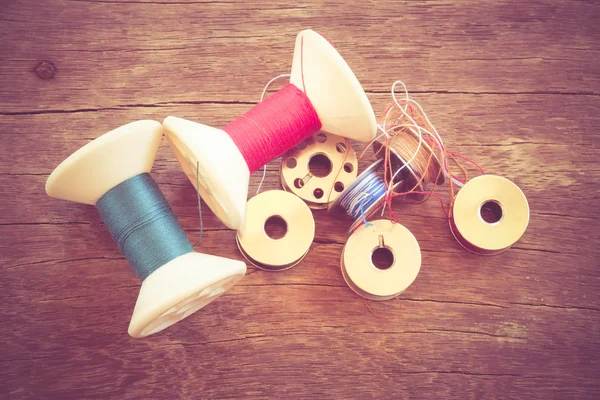 Thread rolls on wood background with filter effect retro vintage — Stock Photo, Image