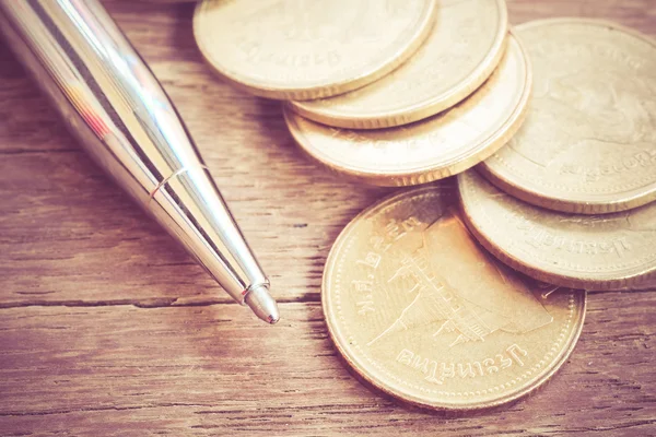 Ручка и монеты с эффектом фильтра ретро винтажный стиль — стоковое фото