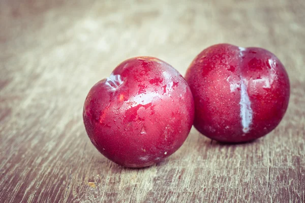 Ciruelas sobre fondo de madera con efecto filtro estilo vintage retro —  Fotos de Stock