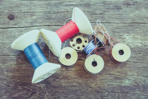 Rouleaux de fil sur fond bois avec effet filtre vintage rétro — Photo