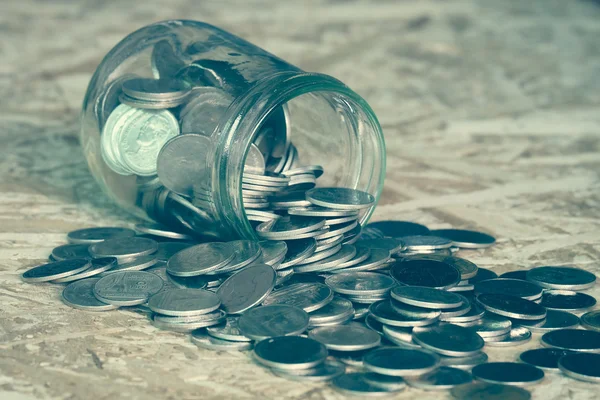 Monety wysypują się z butelki z filtr efektu retro vi — Zdjęcie stockowe