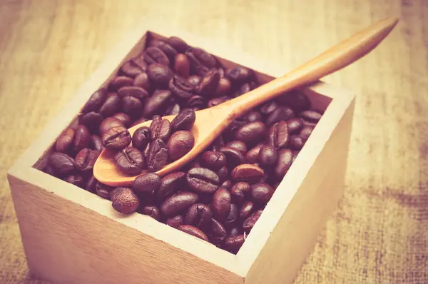 Кофейные бобы и деревянная ложка с эффектом фильтра ретро винтажные с — стоковое фото