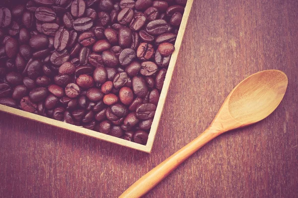 Granos de café y cuchara de madera con efecto filtro retro vintage s —  Fotos de Stock
