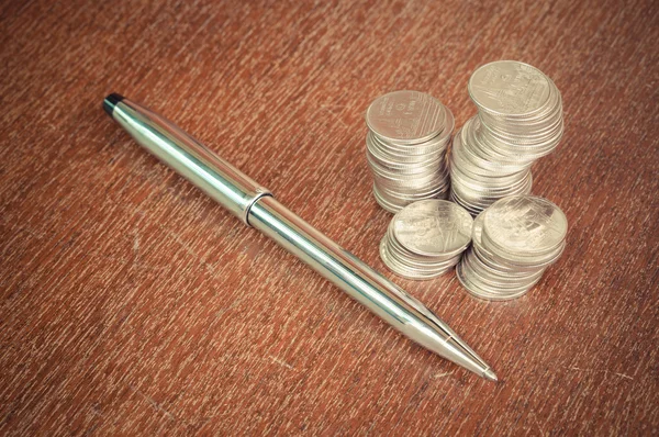 Pen and coins with filter effect retro vintage style — Stock Photo, Image