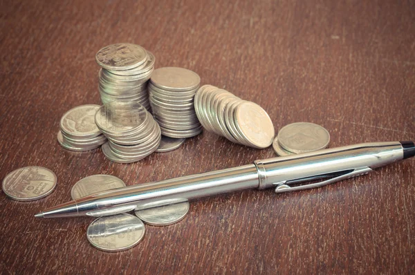 Pen and coins with filter effect retro vintage style — Stock Photo, Image