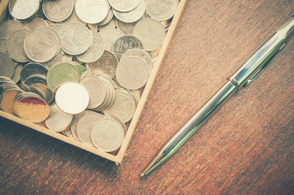 Pen and coins with filter effect retro vintage style — Stock Photo, Image