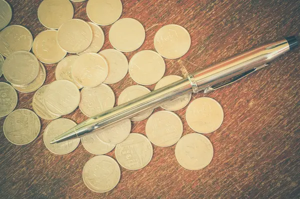 Pluma y monedas con efecto de filtro estilo vintage retro —  Fotos de Stock