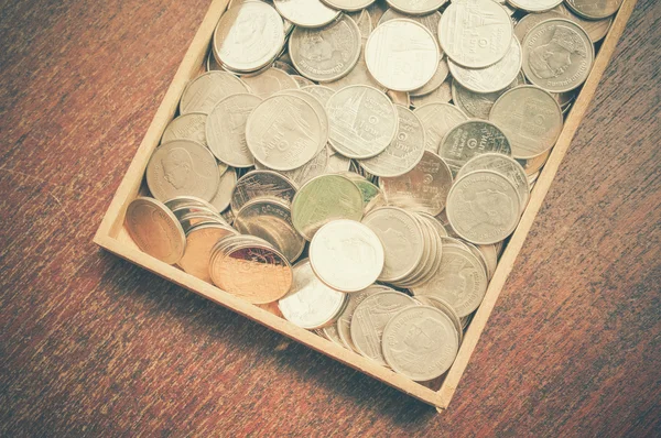 Monedas en madera con efecto de filtro estilo retro vintage —  Fotos de Stock