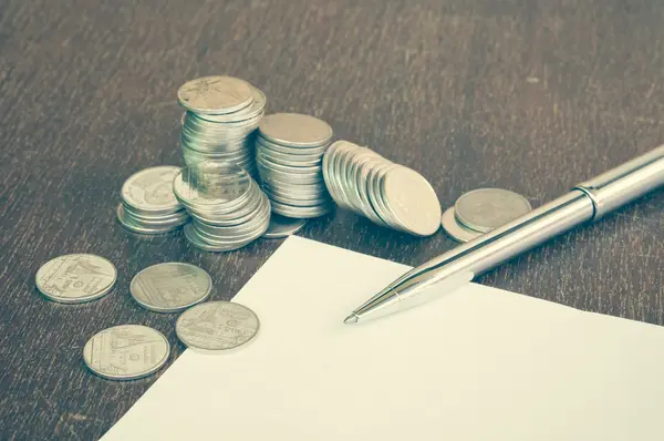 Pen and coins with filter effect retro vintage style — Stock Photo, Image