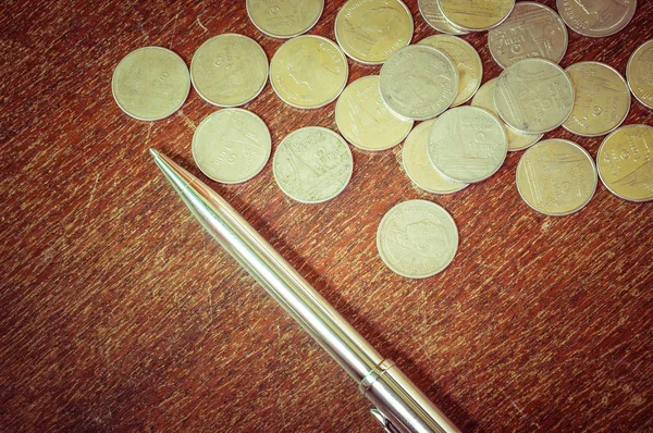 Pluma y monedas con efecto de filtro estilo vintage retro — Foto de Stock